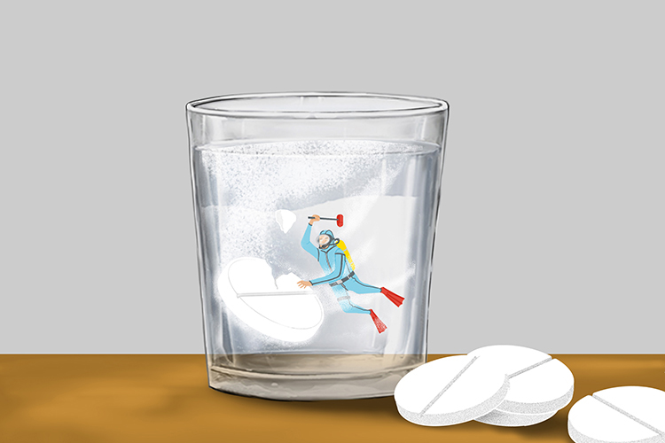 tiny scuba diver breaking up a tablet in a glass of water